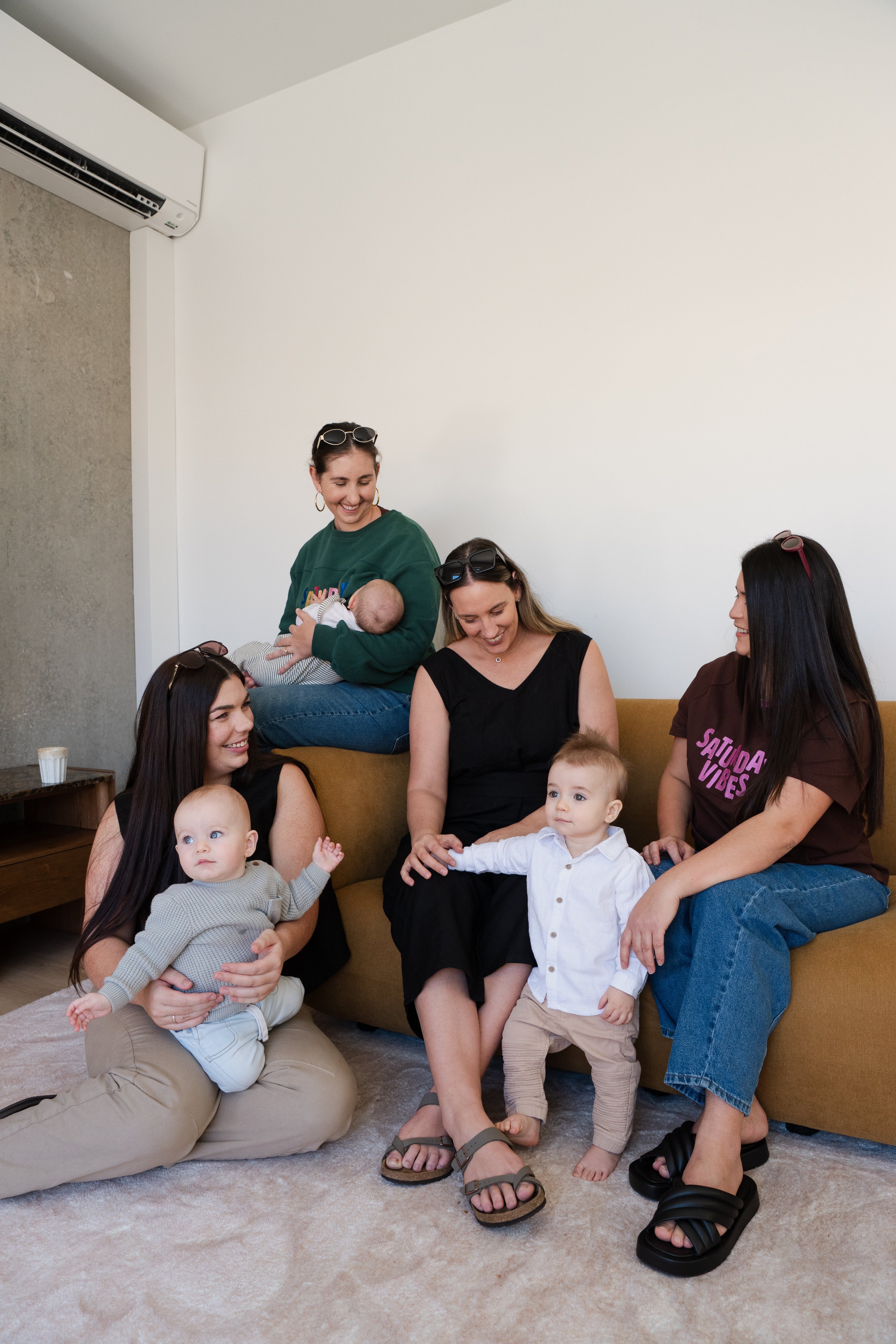 Mums with their babies sitting on a couch. All are wearing Saturday Vibes - bump and breastfeeding friendly clothing.