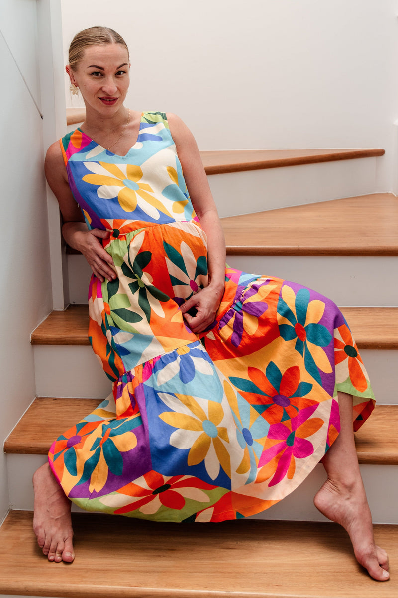 Woman in a colorful dress sitting on a staircase